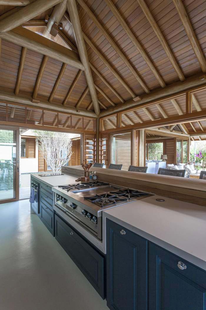 Ilha da cozinha gourmet com fogão range top e bancada de madeira
